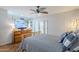 Bedroom with a wooden dresser, TV, ceiling fan, and light-colored walls and trim at 12434 S Ki Cir, Phoenix, AZ 85044