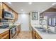 This kitchen features wood cabinets, stainless steel appliances and a stainless sink at 12434 S Ki Cir, Phoenix, AZ 85044