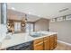A kitchen sink with stainless steel faucet overlooks a great room with ceiling fan and desk at 12434 S Ki Cir, Phoenix, AZ 85044