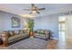 Comfortable living room featuring neutral paint, ceiling fan, and tile flooring with access to the patio at 12434 S Ki Cir, Phoenix, AZ 85044