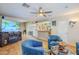 Relaxing living area featuring a TV, decorative bar, blue chairs and a glass coffee table, perfect for entertaining at 12434 S Ki Cir, Phoenix, AZ 85044