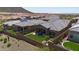 Wide aerial view of a backyard oasis with artificial turf, mountain views and houses with desert surroundings at 13162 W Golden Puma Trl, Peoria, AZ 85383