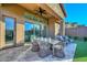Covered patio offering an outdoor dining set and seating area, extending to the landscaped backyard at 13162 W Golden Puma Trl, Peoria, AZ 85383