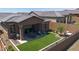 A cozy patio with artificial turf, a covered patio, and lush landscaping, perfect for outdoor relaxation at 13162 W Golden Puma Trl, Peoria, AZ 85383