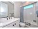 Bright bathroom featuring a white vanity, modern fixtures, and a shower-tub combo with stylish gray and white curtains at 13162 W Golden Puma Trl, Peoria, AZ 85383