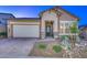Inviting single-story home with a two-car garage, decorative stone accents, and a landscaped front yard at 13162 W Golden Puma Trl, Peoria, AZ 85383