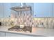 Modern gas range, quartz countertops, and designer backsplash, under a sleek stainless steel range hood at 13162 W Golden Puma Trl, Peoria, AZ 85383