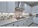 Close-up of the kitchen's gas range, quartz countertops, designer backsplash, and sleek stainless steel range hood at 13162 W Golden Puma Trl, Peoria, AZ 85383