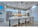 Elegant kitchen featuring white cabinetry, stainless steel appliances, a large island with barstool seating at 13162 W Golden Puma Trl, Peoria, AZ 85383