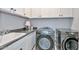 Functional laundry room with modern appliances, sink, counter space, and upper cabinets at 13162 W Golden Puma Trl, Peoria, AZ 85383