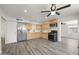 Open kitchen with wood cabinets, stainless steel appliances, and modern gray flooring at 1427 W 6Th Dr, Mesa, AZ 85202