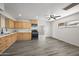 Bright kitchen featuring wood cabinetry, modern appliances, and spacious gray laminate flooring at 1427 W 6Th Dr, Mesa, AZ 85202