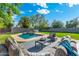 Private backyard features a pool, green grass, and an outdoor seating area with comfortable furniture at 1535 W Berridge Ln, Phoenix, AZ 85015