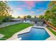 Stunning backyard featuring a sparkling pool, lush lawn, and inviting patio area, perfect for outdoor living at 1535 W Berridge Ln, Phoenix, AZ 85015