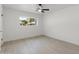Bright, empty bedroom features neutral walls, a sleek fan, modern lighting and a large window at 1535 W Berridge Ln, Phoenix, AZ 85015