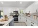 Well-equipped kitchen with stainless steel appliances, white cabinetry, and tiled backsplash at 1535 W Berridge Ln, Phoenix, AZ 85015