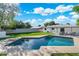 Beautiful backyard showcasing a sparkling pool, expansive green lawn, and outdoor seating area at 1535 W Berridge Ln, Phoenix, AZ 85015