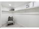Walk-in closet features custom shelving and storage, with a comfortable chair at 1535 W Berridge Ln, Phoenix, AZ 85015
