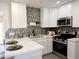 Modern kitchen featuring sleek stainless steel appliances, stylish tile backsplash, and white cabinets at 1561 N Sterling St, Mesa, AZ 85207
