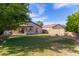 Spacious backyard with a covered patio, grassy area, and brick perimeter wall, ideal for relaxation and outdoor enjoyment at 16209 W Acapulco Cir, Surprise, AZ 85379