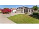 Well-maintained home featuring a lush green lawn, desert landscaping, and a spacious driveway at 16209 W Acapulco Cir, Surprise, AZ 85379