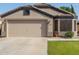 Charming single-story home featuring a neutral stucco exterior, tile roof, and attached two-car garage at 16209 W Acapulco Cir, Surprise, AZ 85379