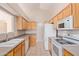 Bright kitchen with wood cabinets, white appliances, and neutral countertops at 16209 W Acapulco Cir, Surprise, AZ 85379