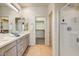 Bright bathroom featuring double sinks, quartz countertop, tile floors and glass enclosed shower at 16420 N Thompson Peak Pkwy # 2101, Scottsdale, AZ 85260