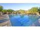 Large community pool surrounded by desert landscaping, a mountain backdrop, and ample lounging chairs at 16420 N Thompson Peak Pkwy # 2101, Scottsdale, AZ 85260