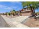 A cozy two-story home with a charming desert landscape, complemented by a palm tree and tiled roof at 17204 E Kensington Pl, Fountain Hills, AZ 85268