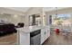 Kitchen with white cabinets, island sink, and stainless steel dishwasher flows into the living room at 17204 E Kensington Pl, Fountain Hills, AZ 85268