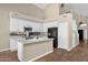 Bright kitchen with white cabinets, island with sink, and stainless steel appliances plus mirrored backsplash at 17204 E Kensington Pl, Fountain Hills, AZ 85268
