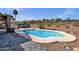 Backyard pool is surrounded by desert landscaping, brick pavers, and a secure wrought iron fence at 17204 E Kensington Pl, Fountain Hills, AZ 85268