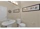 Powder room with pedestal sink, toilet, large mirror, and decorative wall art at 17204 E Kensington Pl, Fountain Hills, AZ 85268