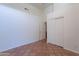 Bedroom with earthy-toned tile flooring, featuring a closet and an open doorway at 1807 W Canary Way, Chandler, AZ 85286