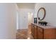 Hallway with wood cabinets, an oval mirror, and warm-toned tile flooring at 1807 W Canary Way, Chandler, AZ 85286