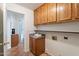 Bright laundry room with tile flooring, wood cabinets, countertop, and ample storage space at 1807 W Canary Way, Chandler, AZ 85286