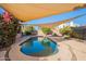 Sun-drenched pool area under shade sails, surrounded by lush landscaping and a private backyard at 1807 W Canary Way, Chandler, AZ 85286