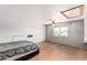 Spacious bedroom with light wood floors, ceiling fan, and large window providing natural light at 1953 E Presidio Rd, Phoenix, AZ 85022