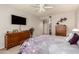 Well-lit bedroom featuring carpeted floors, a ceiling fan, wood furniture, and ensuite bath at 19700 N 76Th St # 1040, Scottsdale, AZ 85255