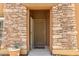 Inviting front entrance with a stone-framed doorway and a welcoming 'OH HELLO' doormat at 19700 N 76Th St # 1040, Scottsdale, AZ 85255