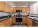 Efficient kitchen featuring wood cabinets, dark countertops, stainless steel appliances, and under cabinet lighting at 19700 N 76Th St # 1040, Scottsdale, AZ 85255