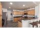 Bright kitchen featuring wood cabinets, dark countertops, stainless steel appliances, tile flooring, and a breakfast bar at 19700 N 76Th St # 1040, Scottsdale, AZ 85255