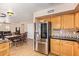 Eat-in kitchen with stainless steel refrigerator, oak cabinets, and tile backsplash at 1991 S Bahama Dr, Gilbert, AZ 85295