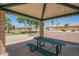 Shaded park area with a picnic table offers a relaxing spot near the basketball court for community enjoyment at 1991 S Bahama Dr, Gilbert, AZ 85295