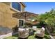 Backyard sitting area with patio umbrella and desert landscaping and flowering bushes at 21813 N 40Th Way, Phoenix, AZ 85050
