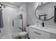 Bright bathroom features a glass-enclosed shower, round mirror, and vanity with modern fixtures at 21813 N 40Th Way, Phoenix, AZ 85050