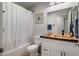 Well-lit bathroom featuring rustic wood countertop, white cabinets, and shower with white curtain at 21813 N 40Th Way, Phoenix, AZ 85050