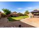 Manicured backyard with lush green lawn, gravel landscaping, and covered patio area at 2230 E Whitten St, Chandler, AZ 85225