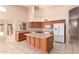 Kitchen boasts an island, refrigerator, tile floors, and wooden cabinets at 2230 E Whitten St, Chandler, AZ 85225
